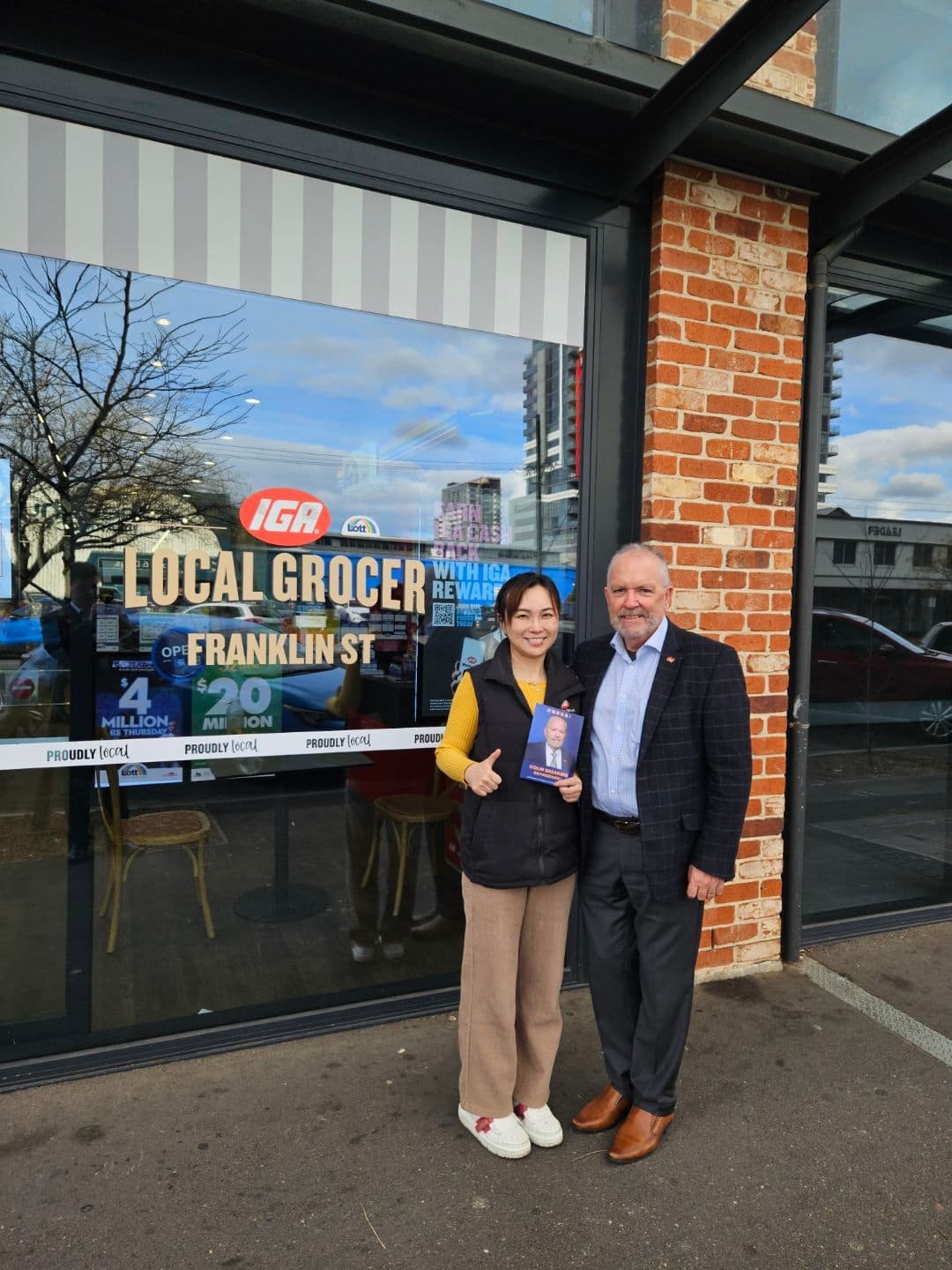 Colin Shearing with a local outside IGA Local Grocer on Franklin Street